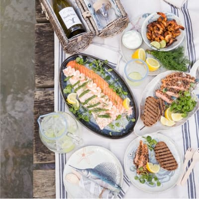Seafood and fish picnic by the lake with a whole salmon
