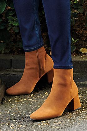 Woman wearing camel suede block-heel boots