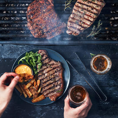 Steaks being cooked on a barbecue