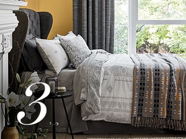 Double bed next to a white-surround fireplace