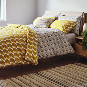 Grey and yellow bedding on a bed