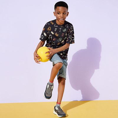 Boy wearing T-shirt, shorts and trainers