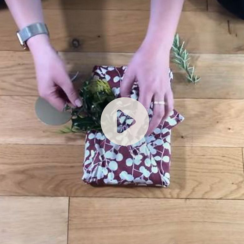 Woman showing how to wrap a gift using the Japanese furoshiki method