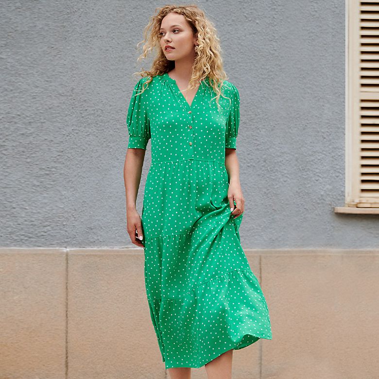 Woman wearing emerald-green polka-dot tiered midi dress