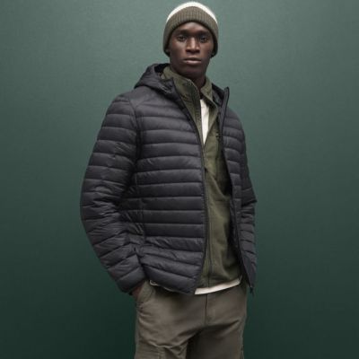 Man wearing padded jacket and beanie hat. Shop men’s new in