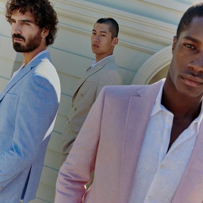 Three men wearing light coloured suits in blue, beige and pink. Shop occasionwear