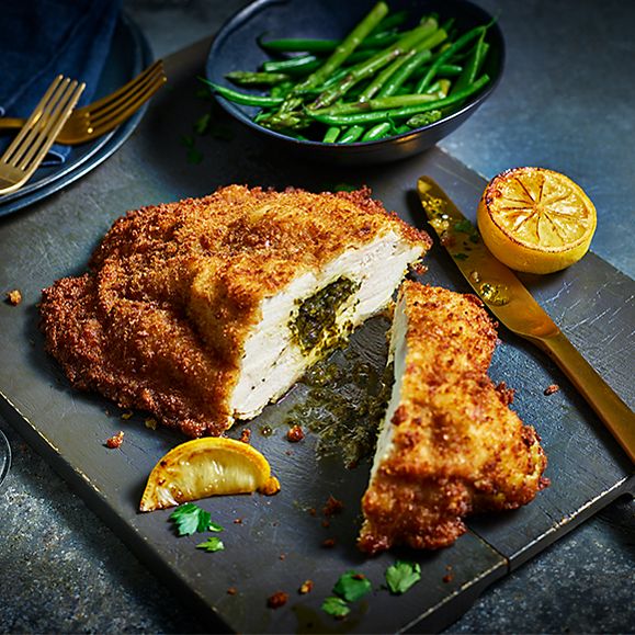 A plate with Our Best Ever chicken Kiev sliced in two
