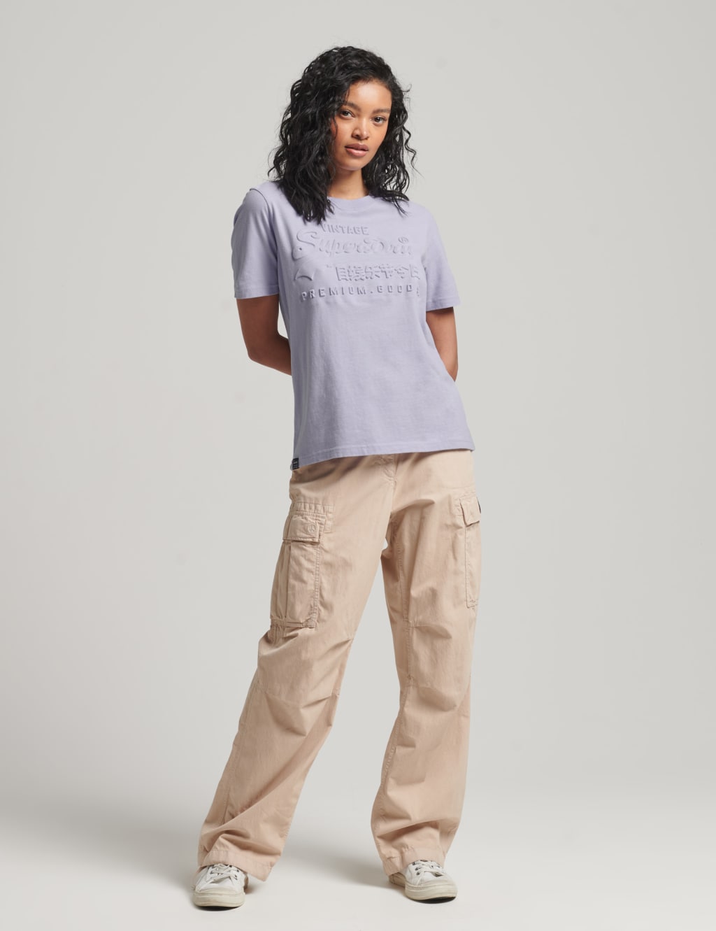 Premium Photo  A woman in a white top and cargo pants stands in