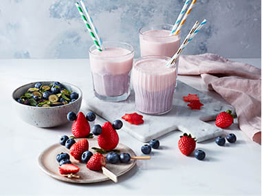 Two-tone berry smoothies, fruit salad and berries on sticks