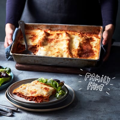 A large, family-sized lasagne and green salad