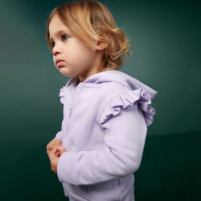 Girl wearing a lilac frilled hoodie. Shop 3 for 2 kidswear