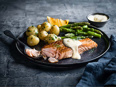 Salmon fillet with hollandaise sauce, potatoes and greens