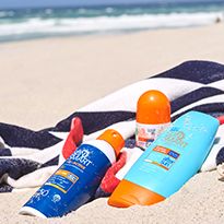 Various sunscreens and sun tan lotions on a beach