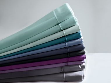 Stack of cotton-rich percale sheets in different colours
