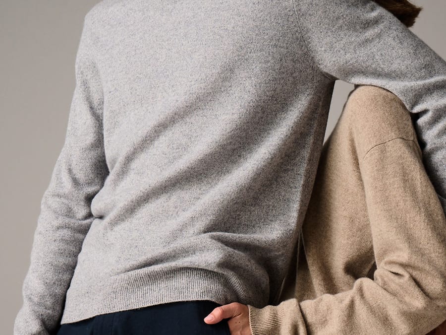 A man and a woman wearing cashmere jumpers. Read more about how we source our materials